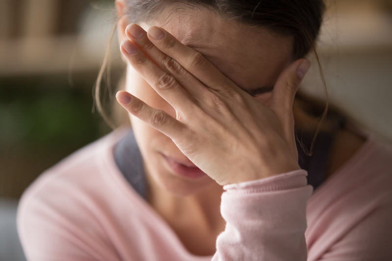 woman holding her forehead because she has a headache