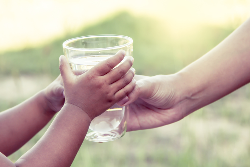 mom handing her child a glass of water