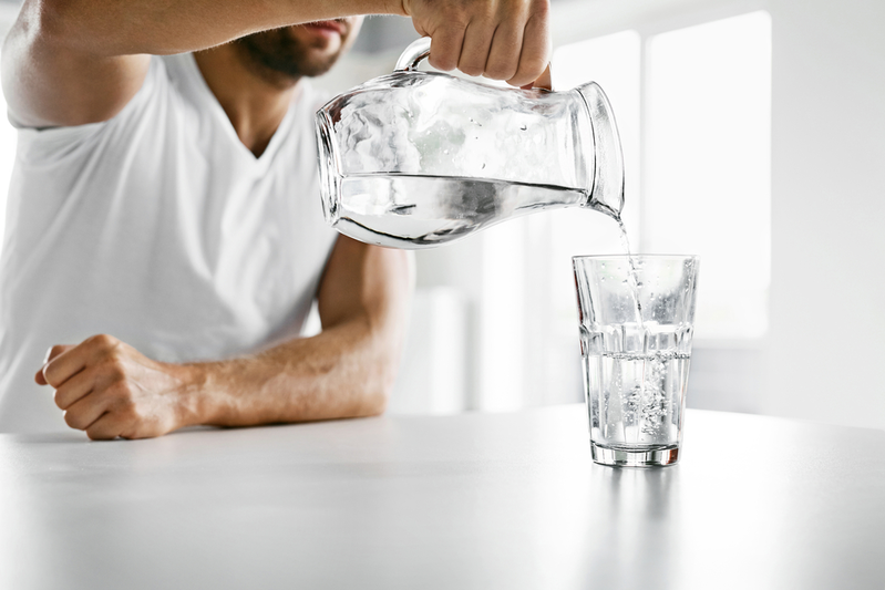 man pouring water into a glass